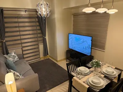 a living room with a table and a television at HAVEN on the 28th in Manila