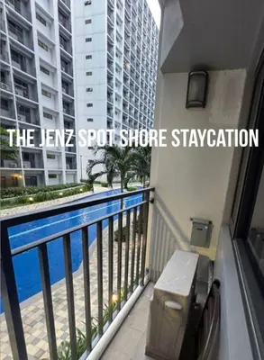 a balcony with a view of a swimming pool at The Jenz Spot Shore Staycation in Manila