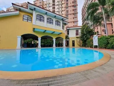 a large swimming pool in front of a building at Modern Studio Condominium 2 in Manila