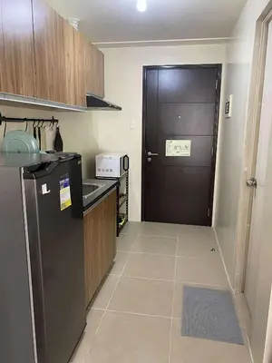a kitchen with a black door and a black refrigerator at Modern Studio Condominium 2 in Manila
