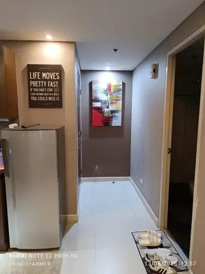 a hallway in a building with a sign on the wall at 1 Bedroom Red Oak Serendra BGC in Manila