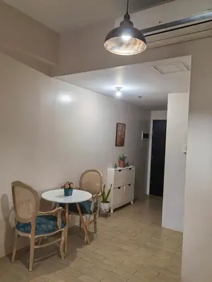 a dining room with a table and chairs and a light at Classy Condotel Across NAIA Terminal 3 in Manila