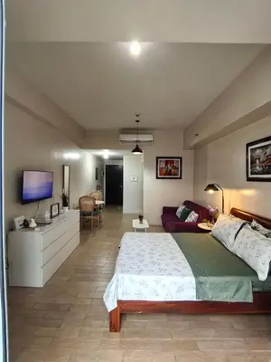 a bedroom with a large bed and a couch at Classy Condotel Across NAIA Terminal 3 in Manila