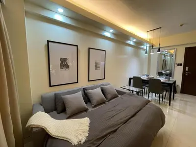 a bedroom with a large bed and a dining room at Pinecrest residential resort in Manila