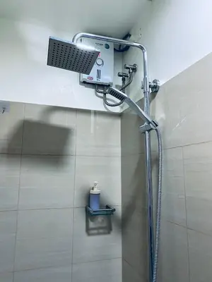 a shower with a shower head in a bathroom at Shore Escape PH in Manila