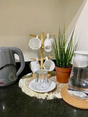 a counter top with a coffee maker and some plants at Shore Escape PH in Manila