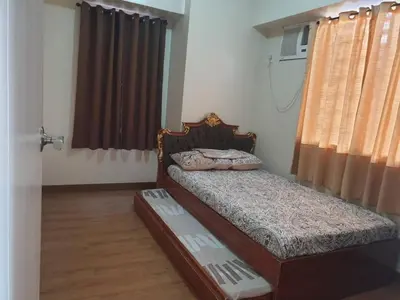 a small bedroom with a bed and a window at Peaceful City View Condo for Rent in Quezon City in Manila