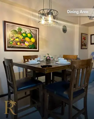 a dining room table with chairs and a painting on the wall at Radiance Suite in Manila