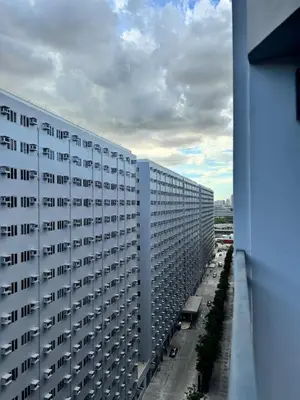 a view of a large white building from a window at Del Rosario Place Shore 2 Residence in Manila