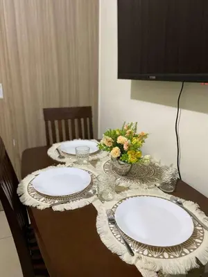a table with two white plates and flowers on it at Shore 2 Residence Tower 2 in Manila