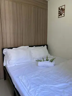 a bed with white sheets and plants on it at Shore 2 Residence Tower 2 in Manila