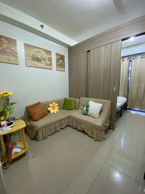 a living room with a couch with pillows on it at Shore 2 Residence Tower 2 in Manila