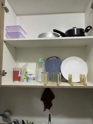 a kitchen shelf with dishes and other kitchen items at AJ Staycation Shore 2 in Manila