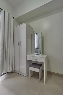 a white dressing table with a mirror and a stool at MOA Shorescape City Life with WiFi in Manila