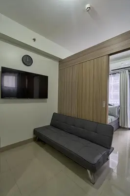 a living room with a couch and a flat screen tv at MOA Shorescape City Life with WiFi in Manila