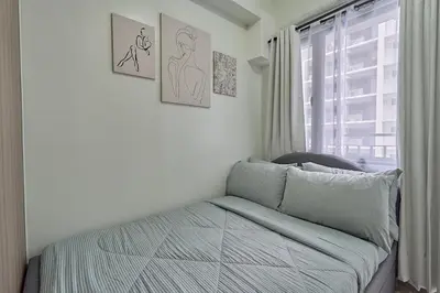 a bedroom with a bed and a window at MOA Shorescape City Life with WiFi in Manila