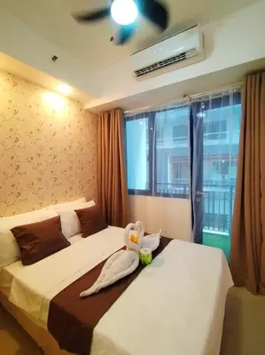 a bedroom with two beds and a window at Sea Residences - MOA in Manila
