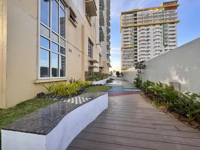 a walkway between two buildings with a bench at Urban Oasis Studio at Central District Makati in Manila