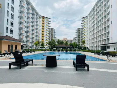 a pool with two chairs and a table and some buildings at Field Residences by Diane in Manila