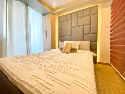 a bedroom with a large bed and a large window at Azure Cozy Hotel by CM staycation in Manila