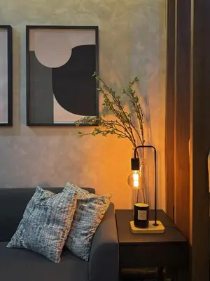 a living room with a couch and a table with a lamp at Sleek Designer Studio at Knightsbridge Residences in Manila