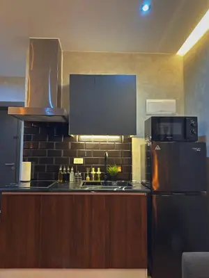 a kitchen with a refrigerator and a microwave at Sleek Designer Studio at Knightsbridge Residences in Manila