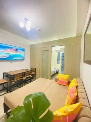 a living room with a couch and a dining room at LiCa Place in Manila
