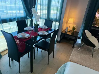 a dining room with a table and chairs and a room with windows at Airport View Walk to NAIA 3 in Manila