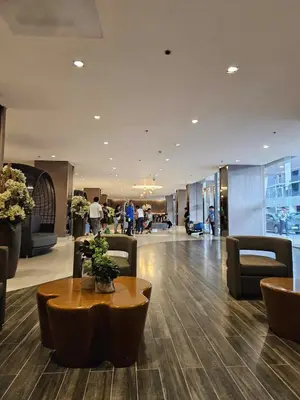 a lobby with a table and chairs in a building at Cozy 1BR beside MOA with Wifi, Netflix, Pool & Washer in Manila