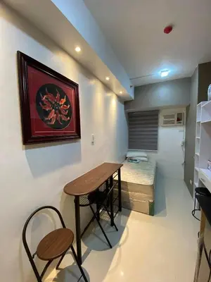 a room with a table and two chairs and a bed at Aral Realty and Property Management in Manila