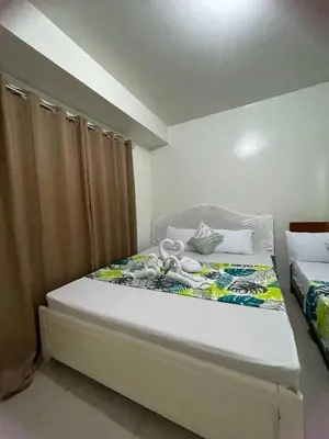 a bedroom with a large bed with at 1148a 3br 1-king size 1queen size 2 double size 2-single size 1-extra matress Moa view in Manila