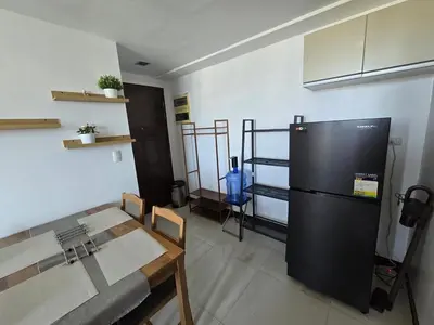 a kitchen with a black refrigerator and a table at Cozy Corner Studio in McKinley Walk to Venice Mall in Manila