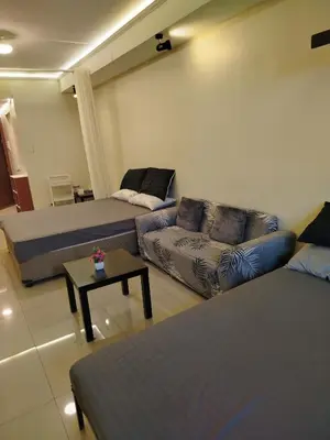 a living room with two beds and a couch at Shell Residences MOA 2 beds by Dad's in Manila