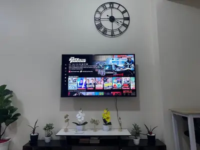 a tv hanging on a wall with a clock at Bayfront Staycation at The Radiance Manila Pet-Friendly, Free Pool & Gym near Airport, MOA, Star City, Manila World Trade Center & Manila Bay in Manila