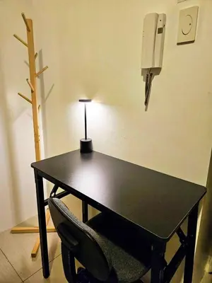 a black table with a chair and a lamp at Spacious 1BR beside MOA with Wifi, Netflix, Pool & Washer in Manila