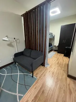 a living room with a couch and a lamp at Staycation Alabang by Larsen in Manila
