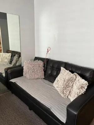 a black leather couch with pillows on it at Amaia skies cubao in Manila