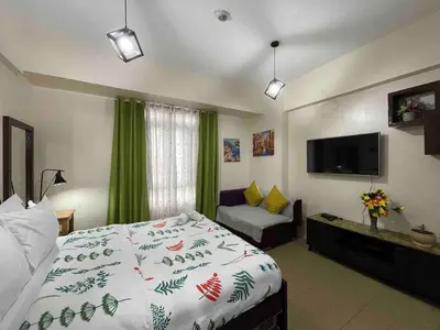 a bedroom with a bed and a flat screen tv at Cozy Condo near NAIA T3 in Manila