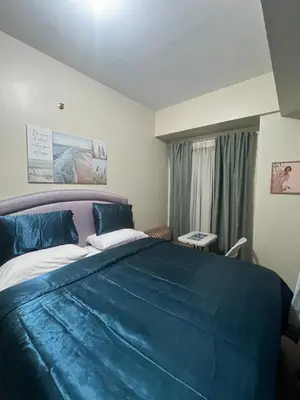 a bedroom with a large bed with blue sheets at Altitude Abode at Eighty One Across NAIA 3 in Metro Manila in Manila