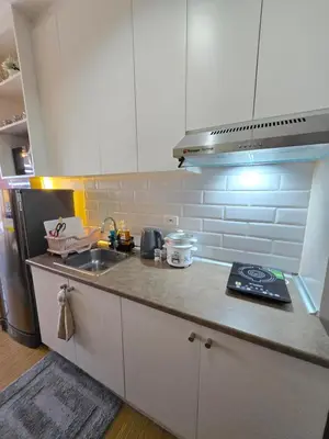 a kitchen with a sink and a counter top at The Snug Spot at Grace Residences Taguig in Manila