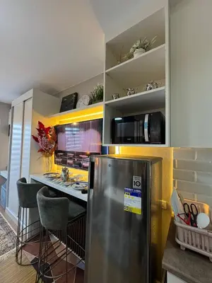a kitchen with a stainless steel refrigerator and a counter at The Snug Spot at Grace Residences Taguig in Manila