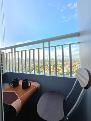 a balcony with two coffee cups on a desk at The Snug Spot at Grace Residences Taguig in Manila