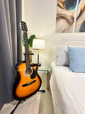 a guitar sitting next to a bed in a bedroom at 1BR Condotel in Azure Urban Resort Near NAIA #BH1 in Manila