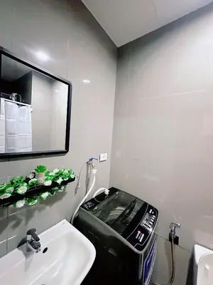 a bathroom with a trash can next to a sink at Air Residences staycation2 in Manila