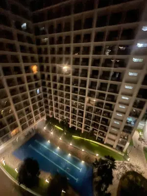 a large building with a swimming pool in front of it at Shore Stay in Manila
