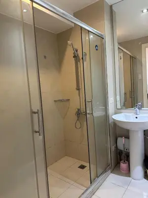 a bathroom with a shower and a sink at Stylish City View Flat Cozy with Netflix WIFI in The Knightsbridge Residences in Manila