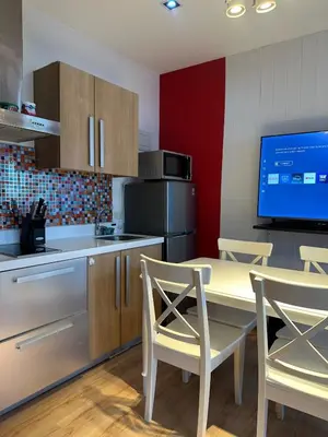 a kitchen with a table and chairs and a television at Stylish City View Flat Cozy with Netflix WIFI in The Knightsbridge Residences in Manila
