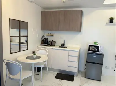 a small kitchen with a small table and a microwave at A peace crib Eastwood in Manila