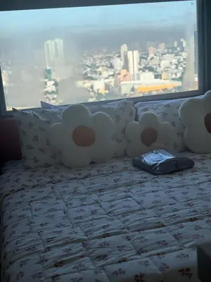 a bed in a room with a large window at Columbres Place in Manila