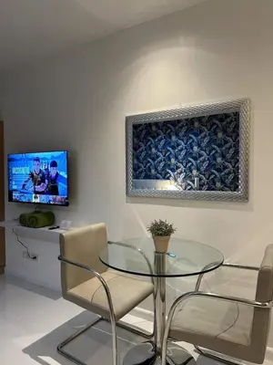 a dining room with a glass table and chairs at Modern Studio with Balcony in The Gramercy Residences in Manila